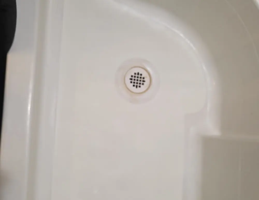 Shower pan after professional refinishing, clean white finish